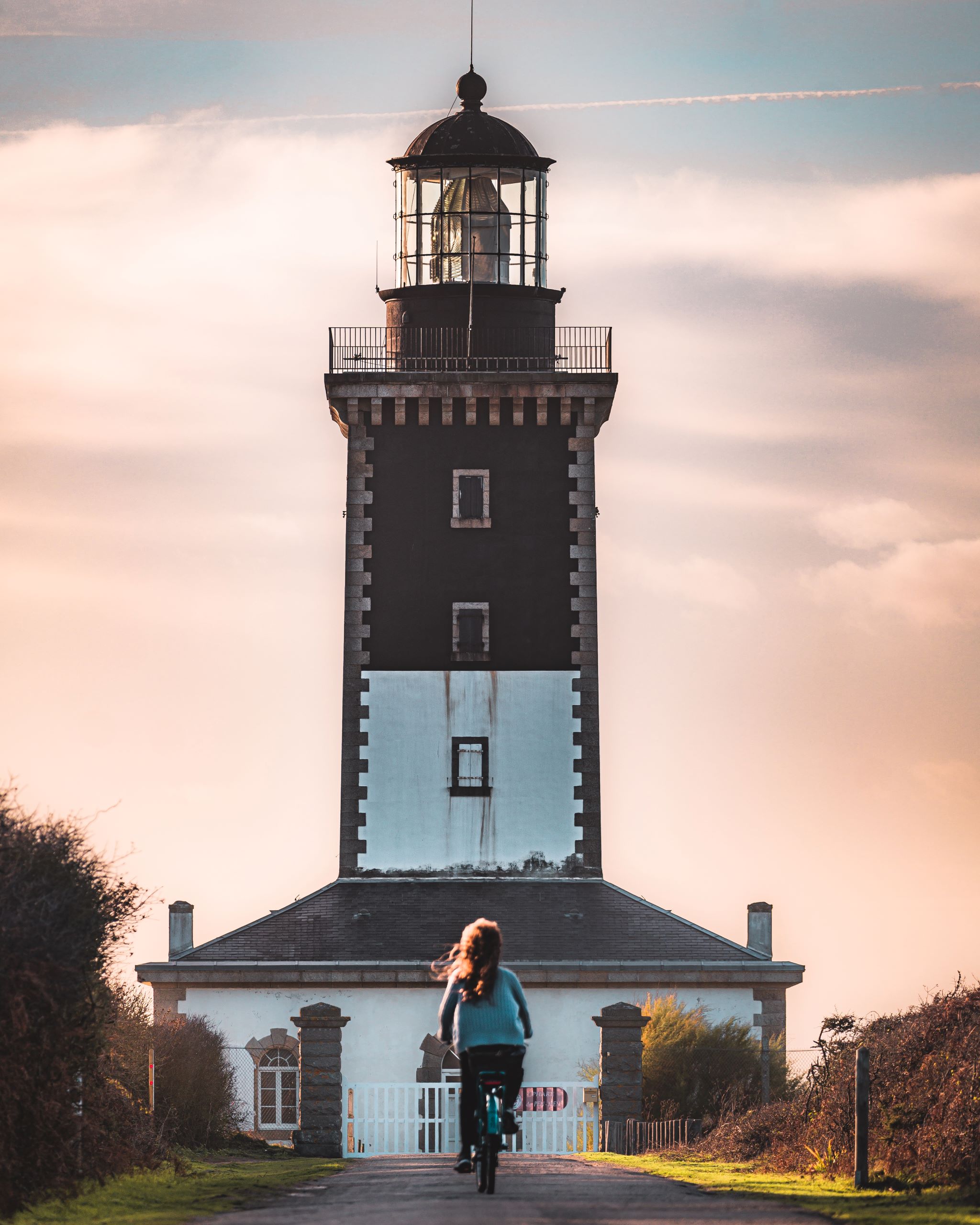 Balade à vélo au coucher de soleil devant le phare de Pen Men, sur l'île de Groix (Morbihan) - ©Lezbroz - LBST